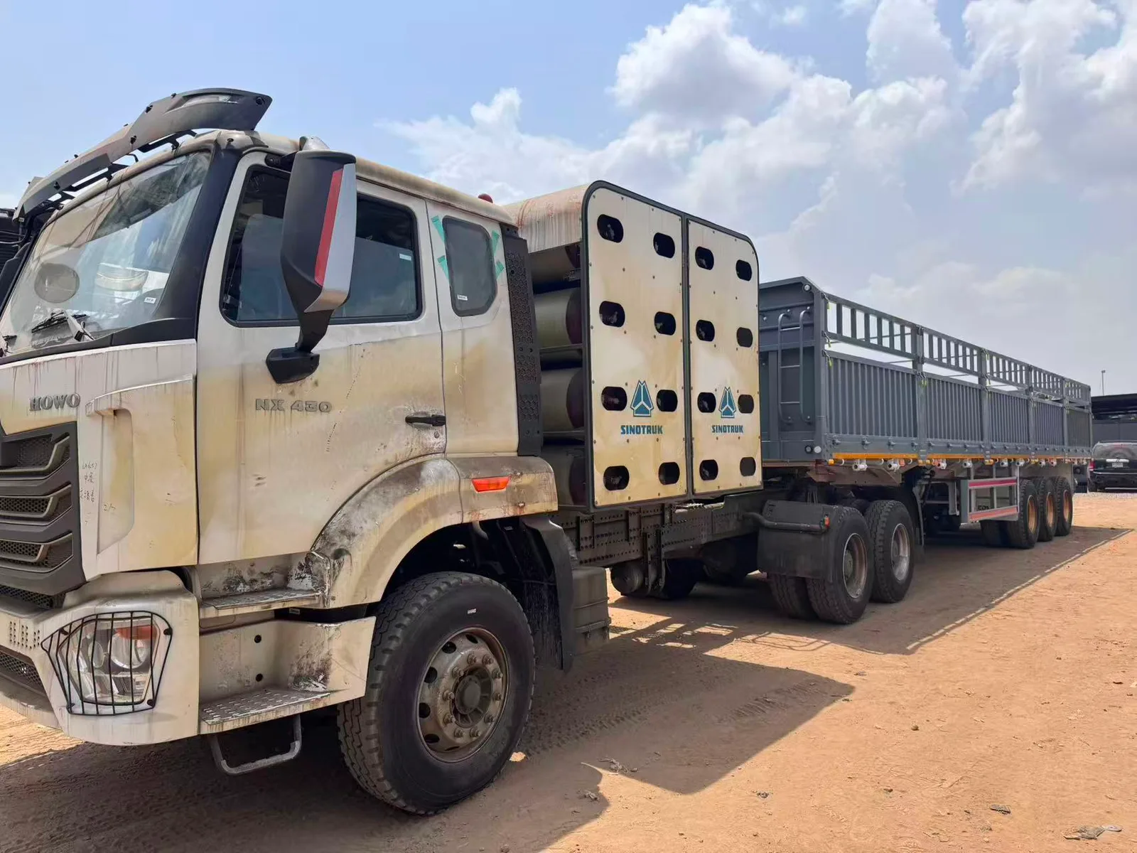 SINOTRUK HOWO NX450 CNG tractor truck with visible CNG cylinders and sidewall semi-trailer